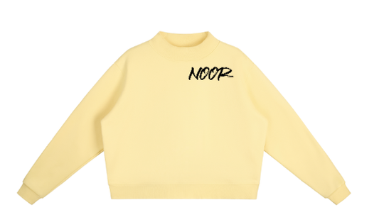 Yellow sweatshirt with 'NOOR' text on a white background